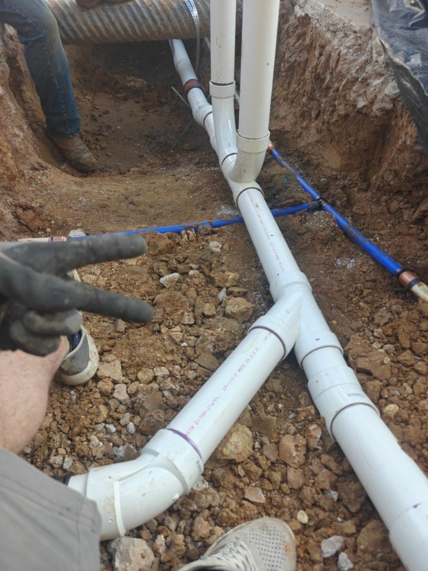 New PVC lines laid in an open trench during a repipe
